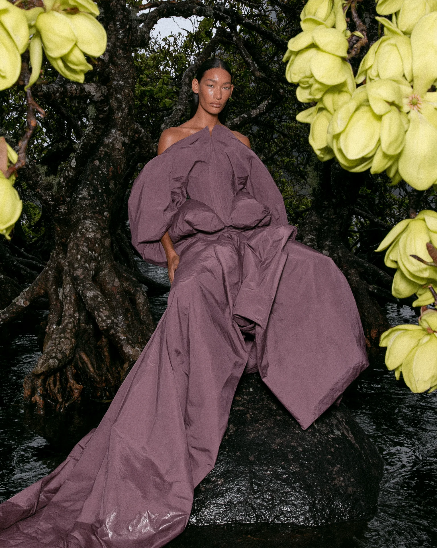 Mauve-purple flowing gown leaning against a tree with giant yellow-green flowers